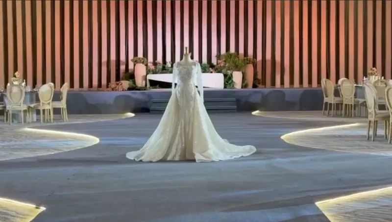 The bridal gown on a grey aisle edged with flowing gold light lines