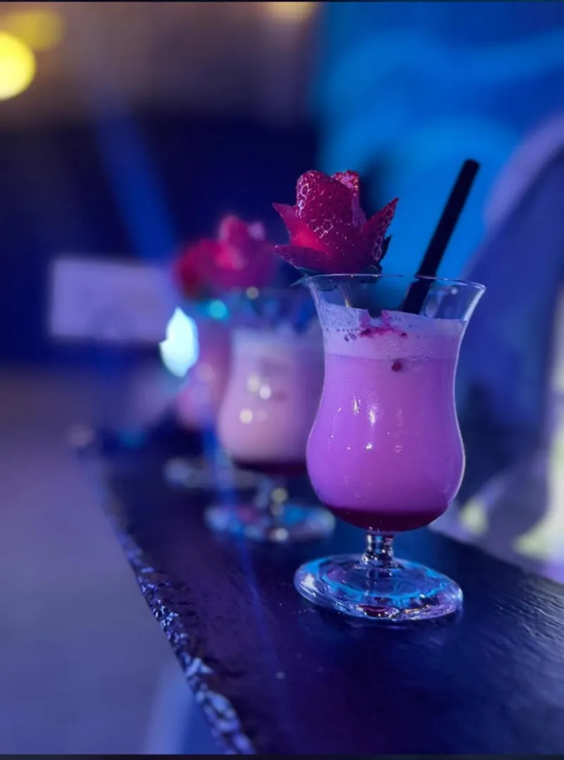 Pink drinks garnished with a rose in glass cups