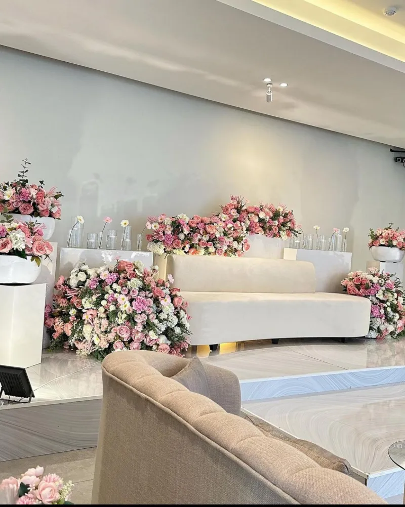 A milcha setting with a white sofa and tiers of pink roses