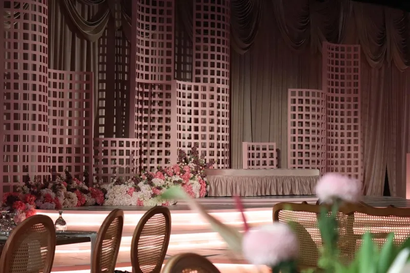 A kosha of blush lattice towers and soft florals on a lit stage